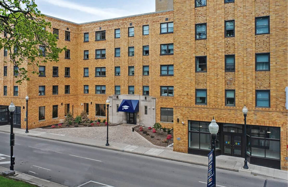 Brick building with blue entrance canopy.