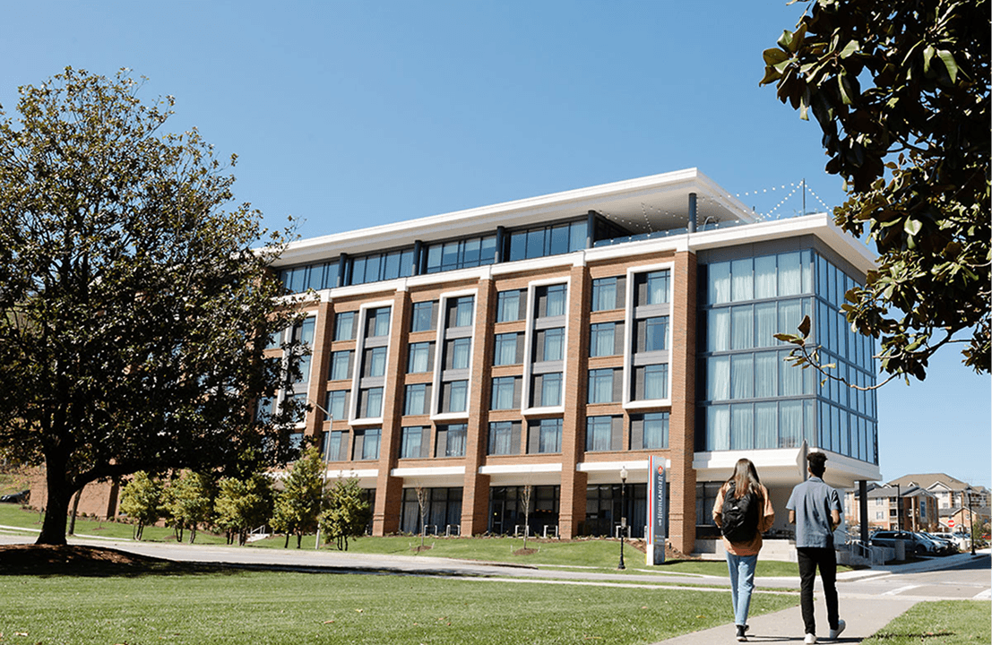 Two people walking toward a modern building.