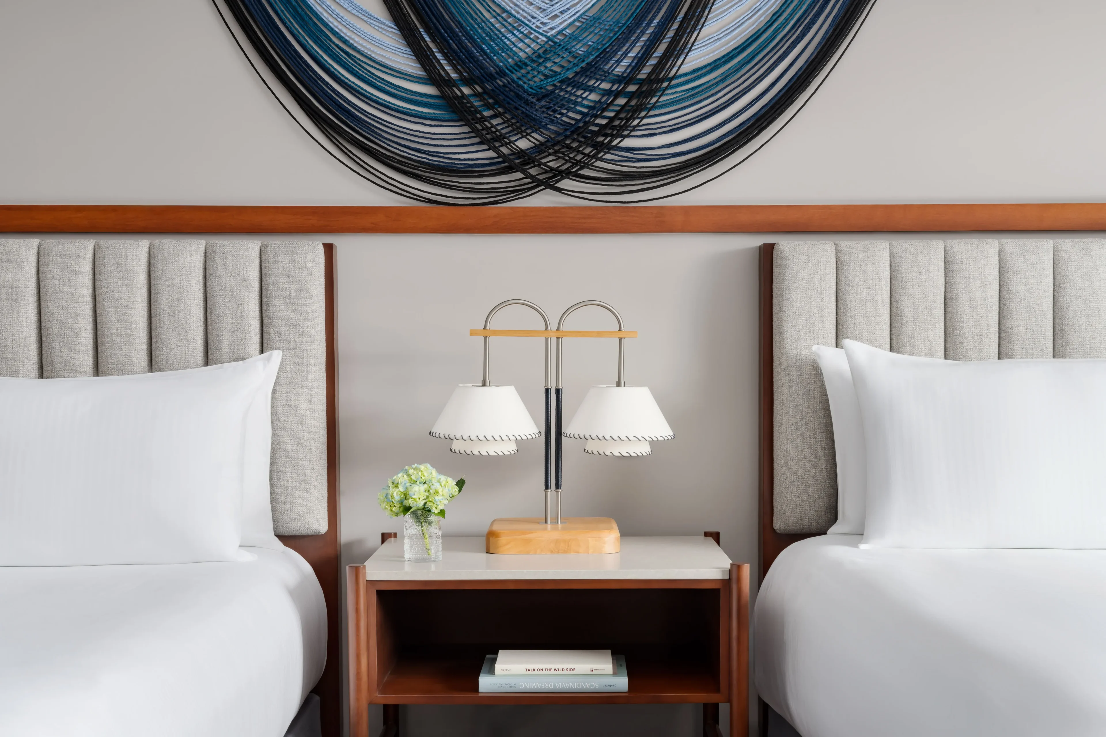 Hotel room with two beds and lamp.