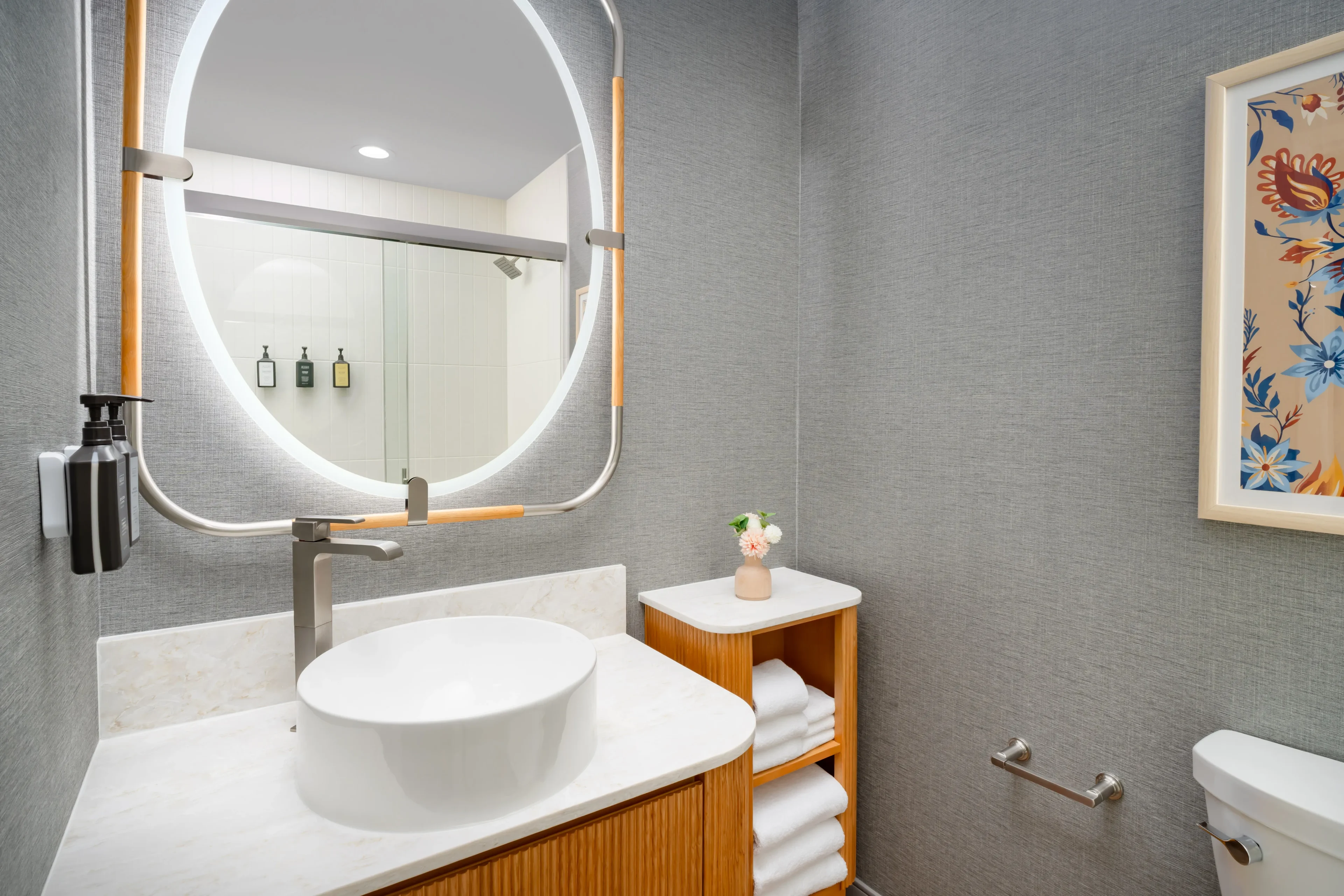 Modern bathroom with round mirror and sink.