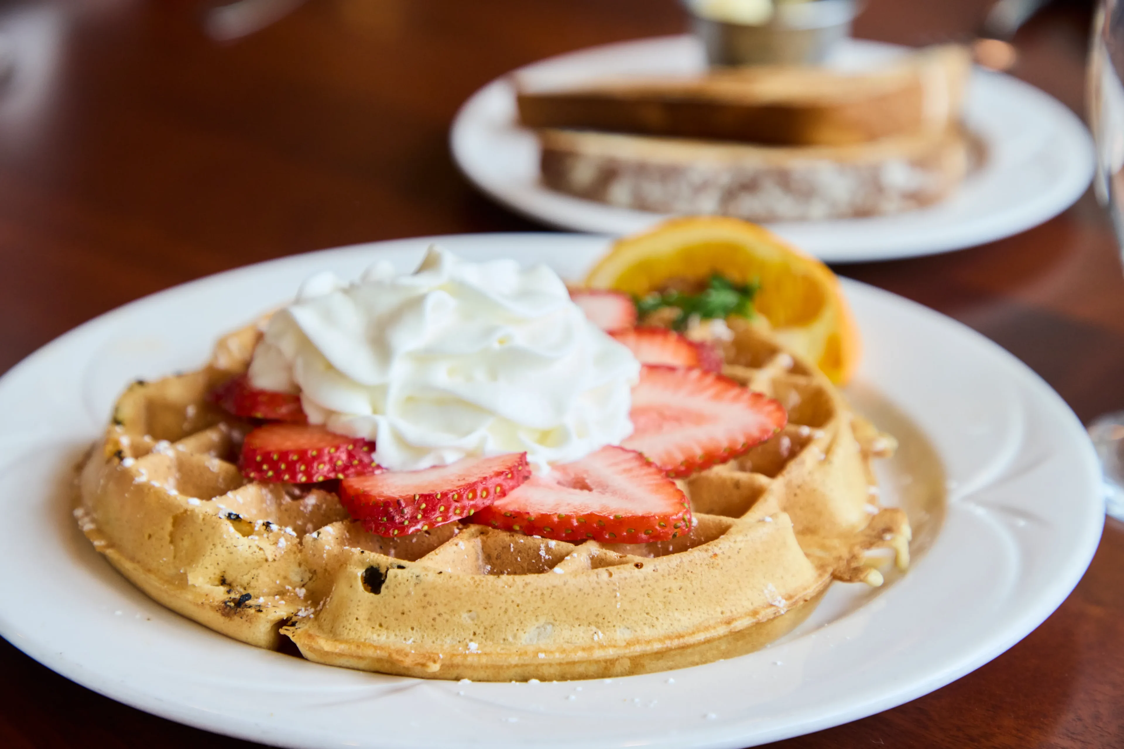 Waffle with strawberries and whipped cream.