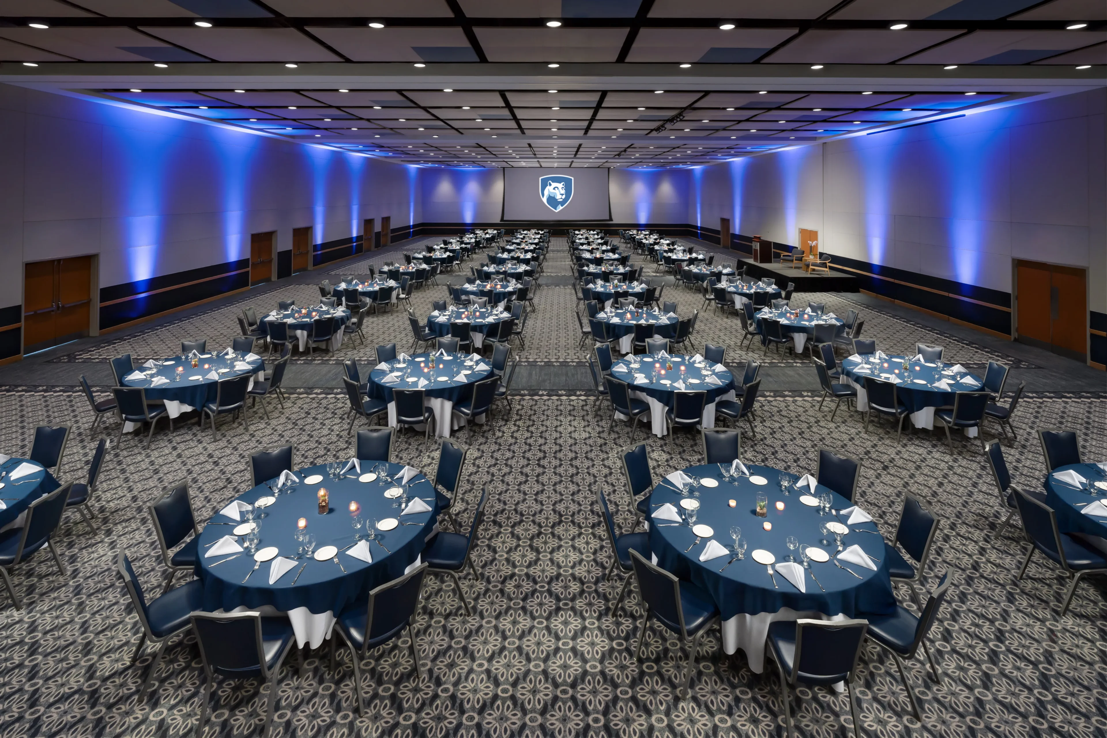 Large banquet hall with round tables set.