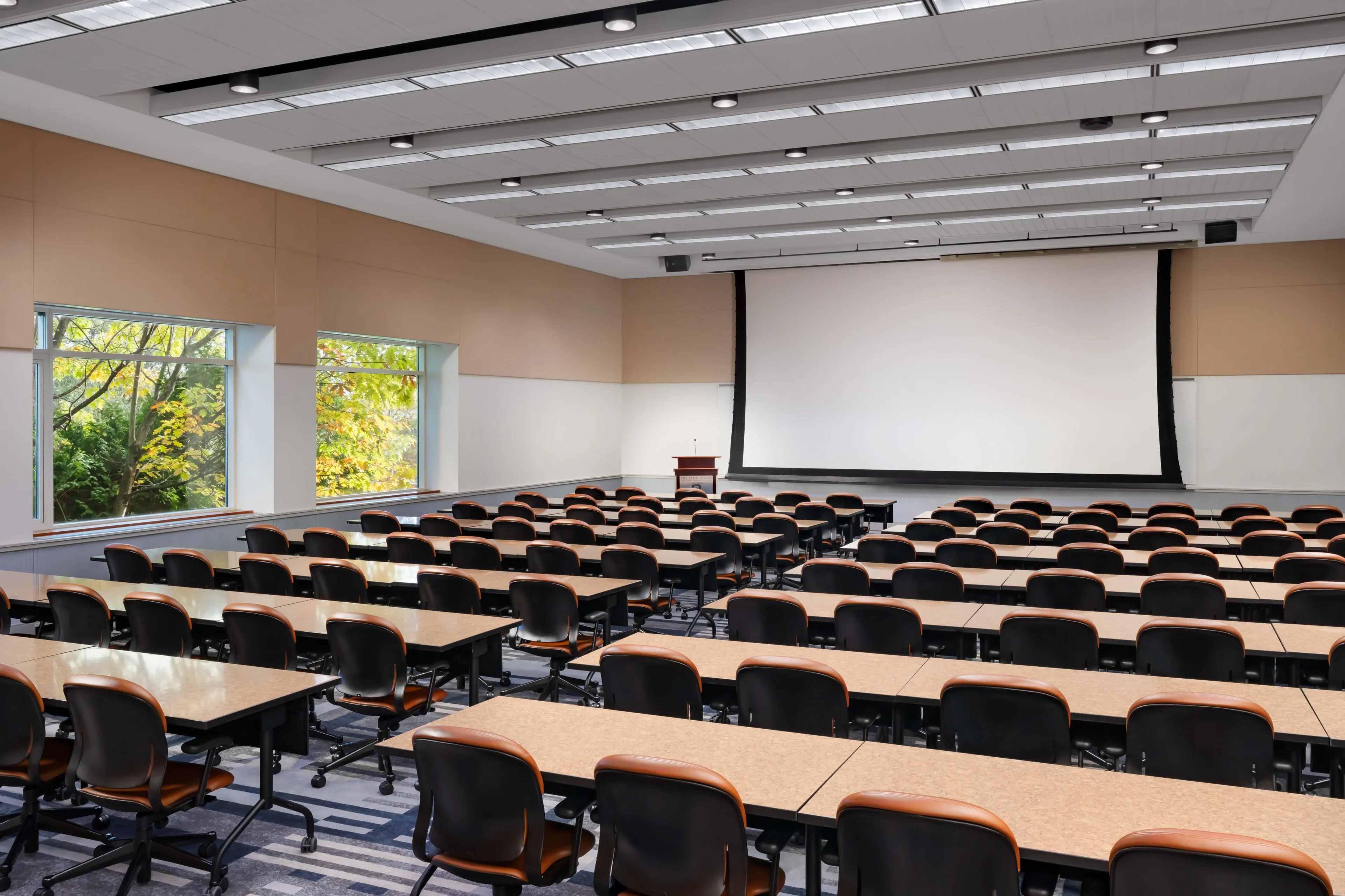 Empty lecture hall with rows of tables.
