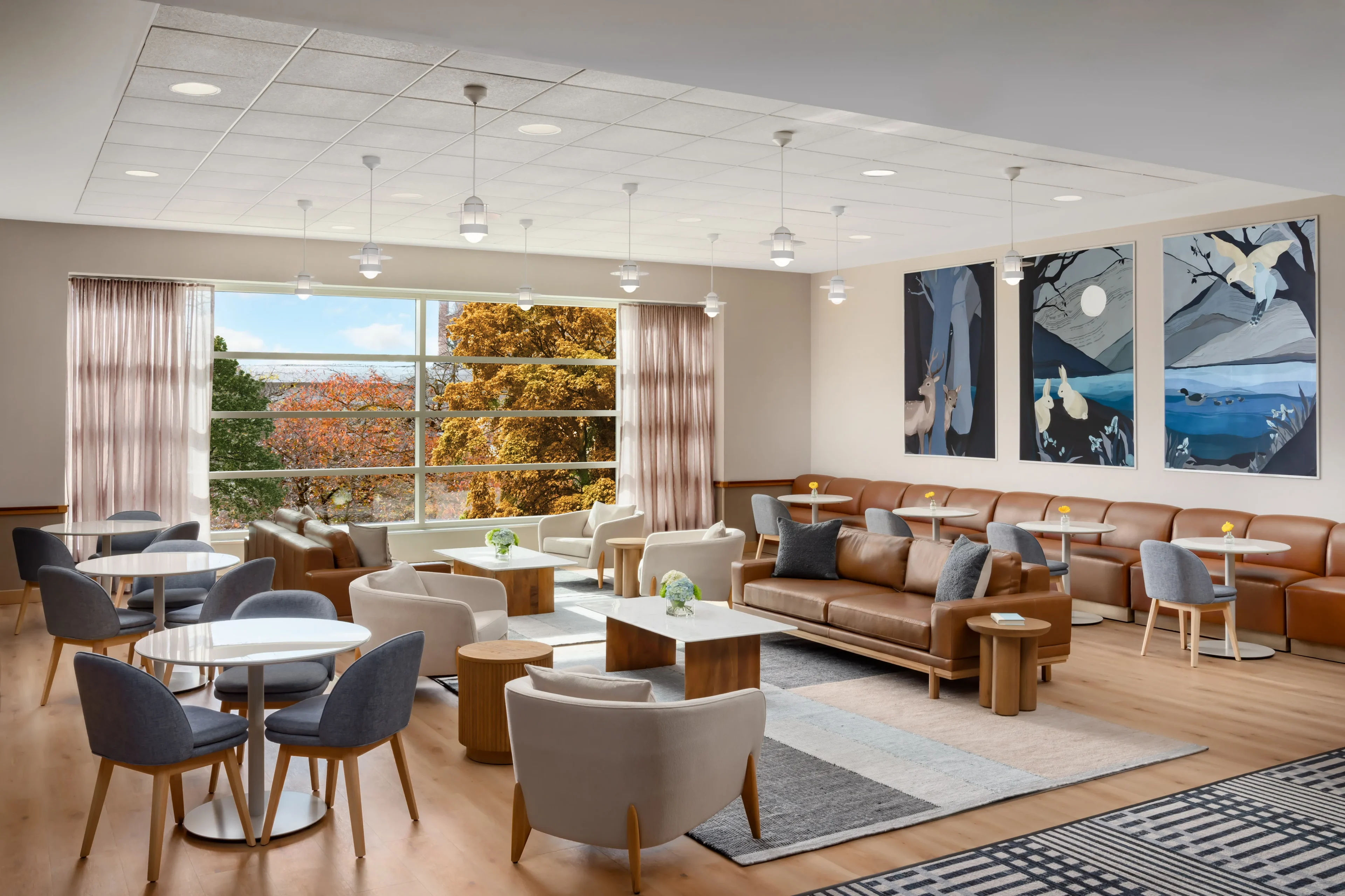 Modern lounge with seating and large windows.