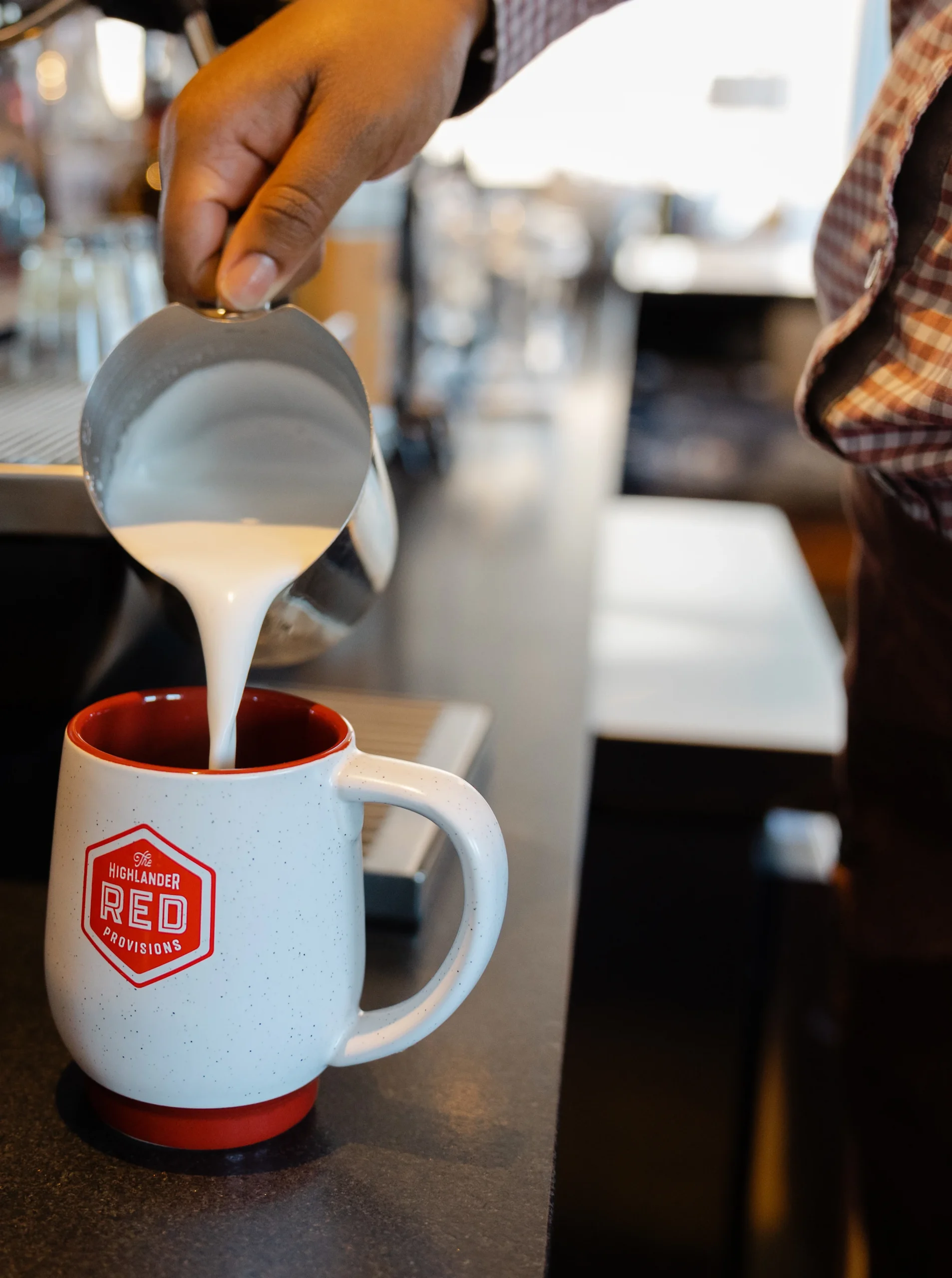 Pouring milk into a coffee mug.