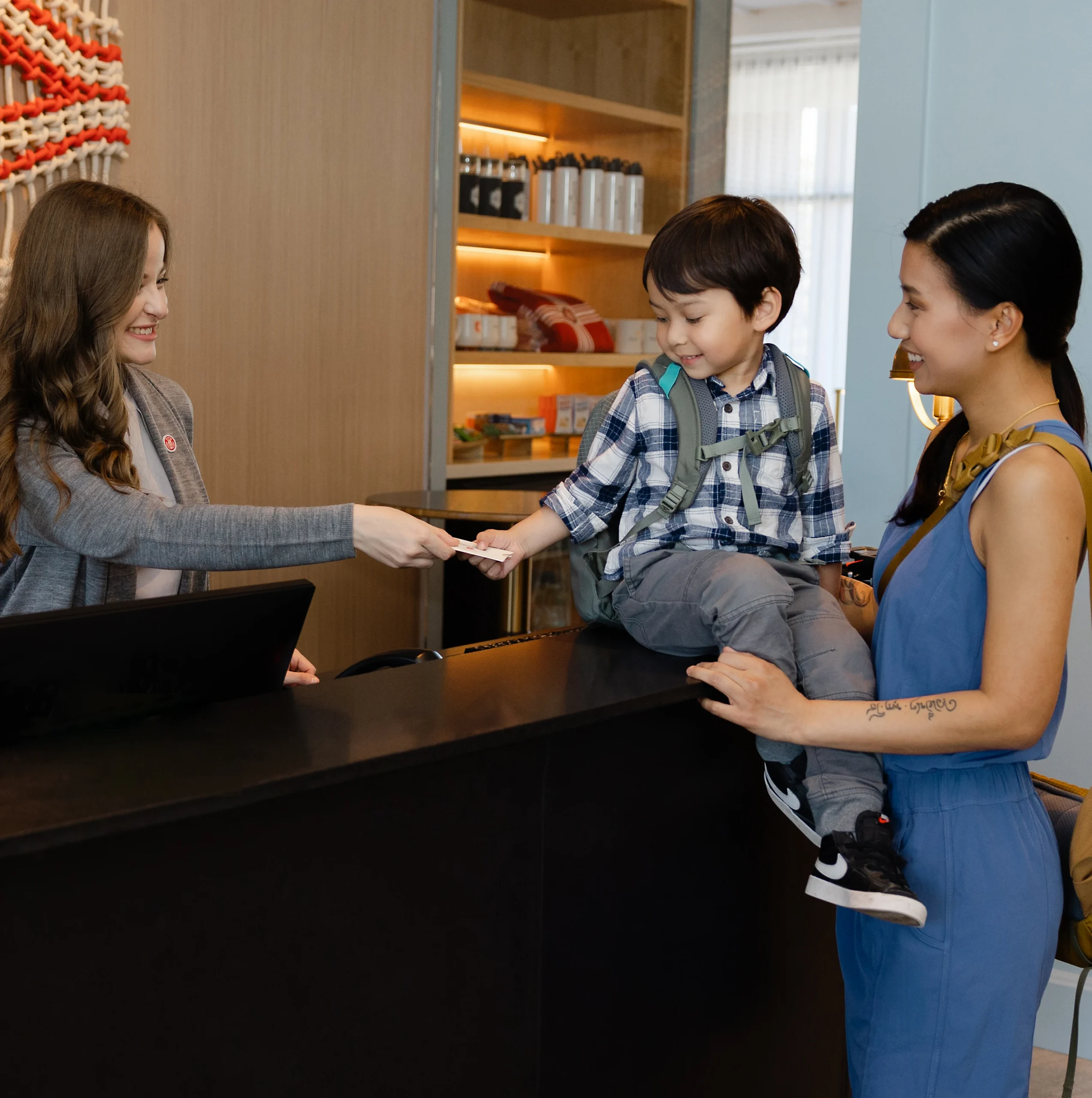 Child at reception desk with two women.