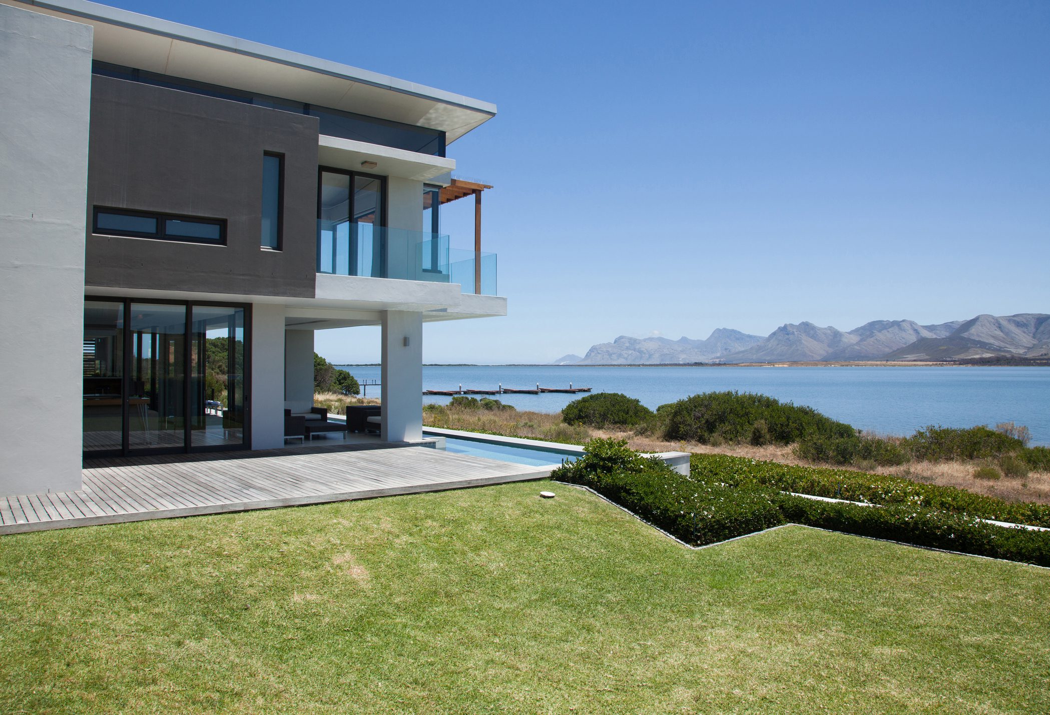 Modern house by the ocean, sunny day.