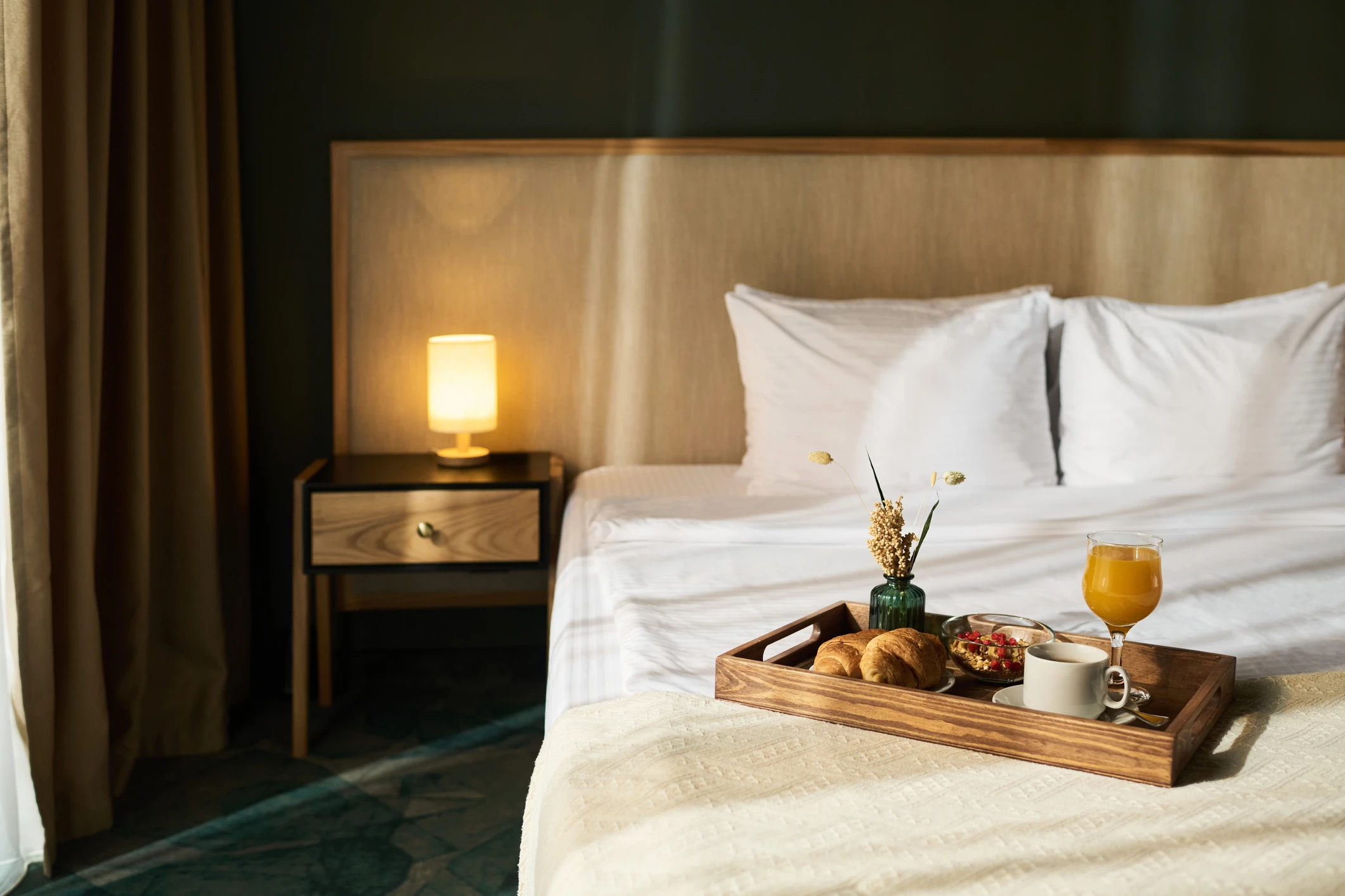Breakfast tray on cozy hotel bed.