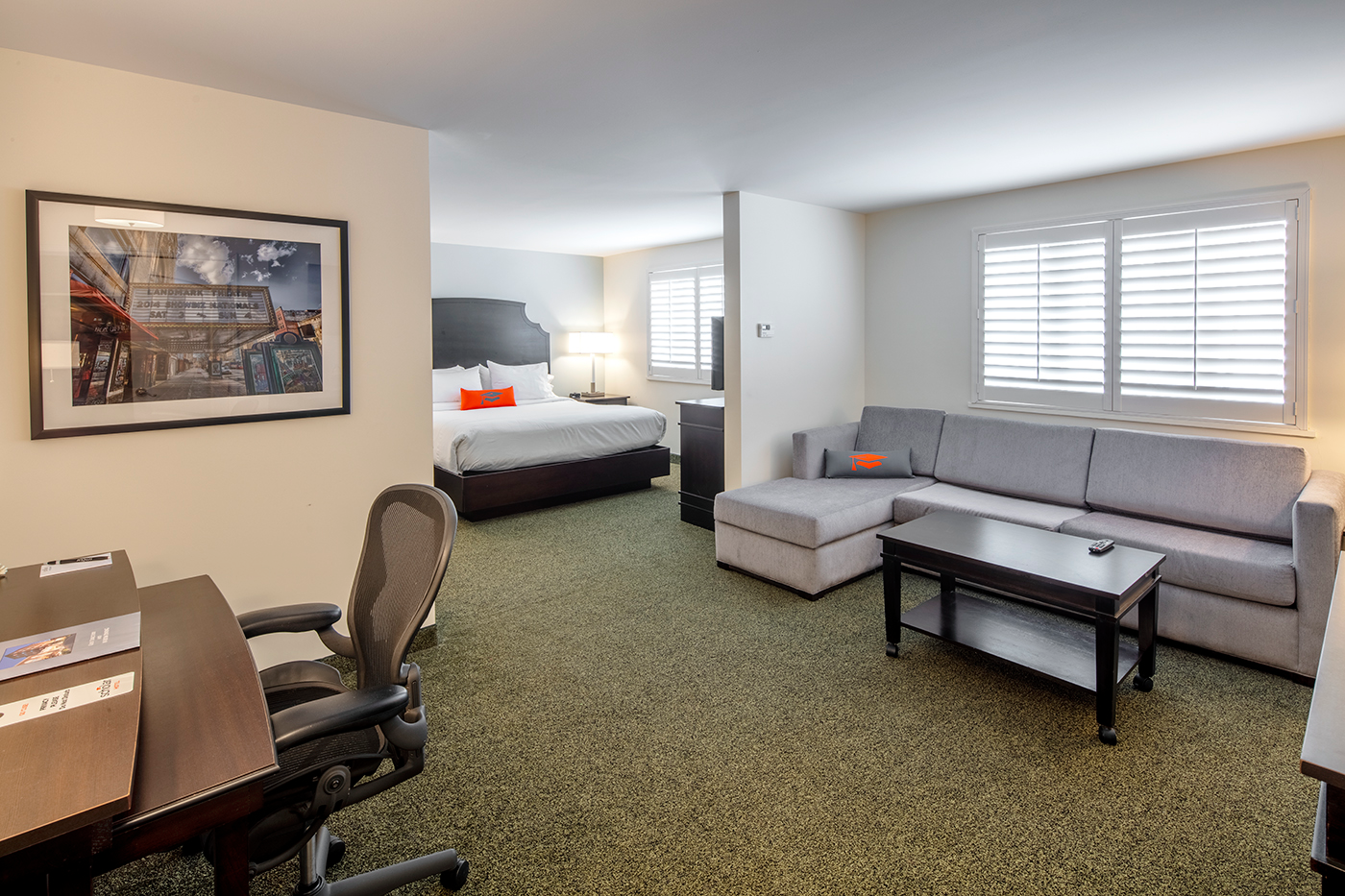Spacious hotel room with bed and sofa.