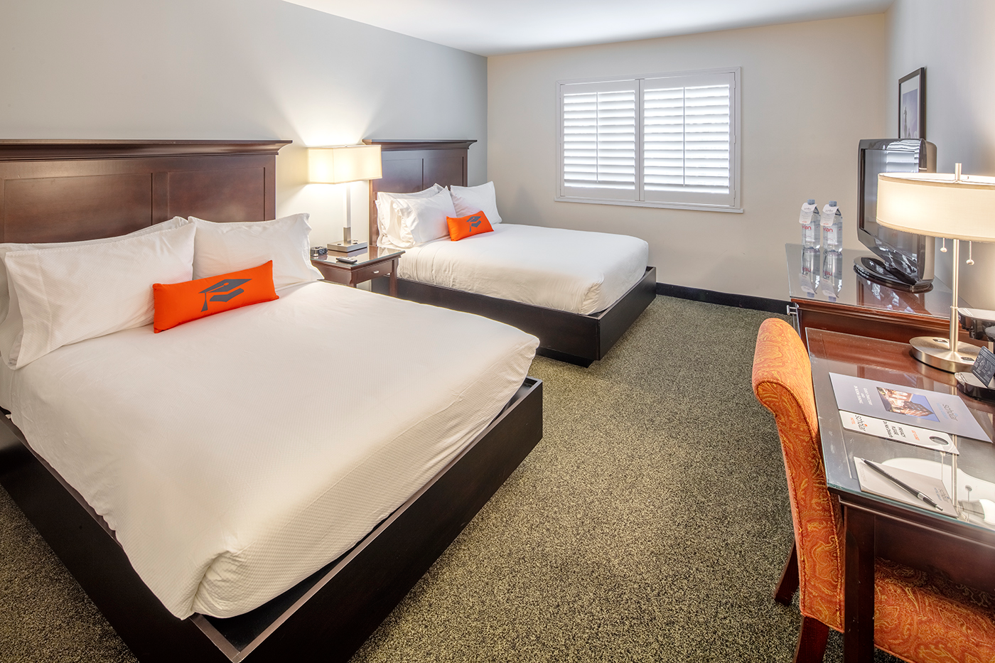 Hotel room with two beds and desk.